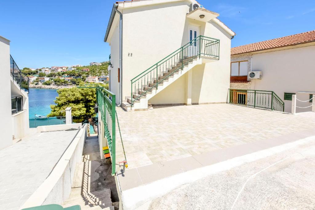 a house with a balcony and a view of the water at Apartments Ivica in Primošten