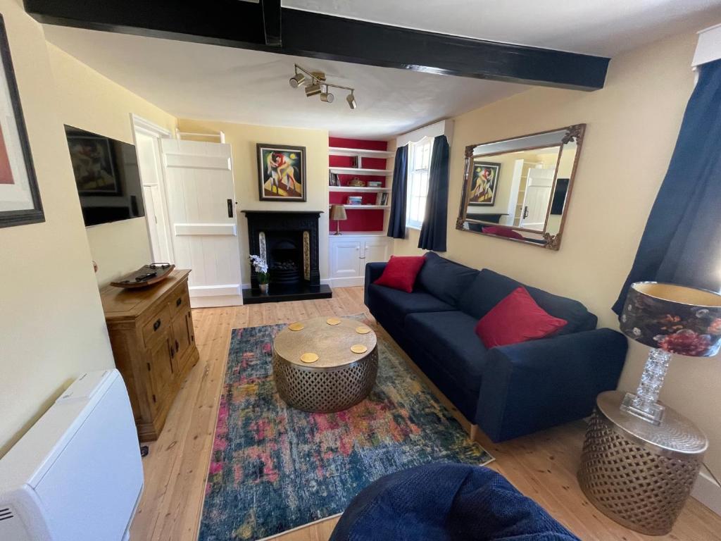 a living room with a blue couch and a fireplace at Central townhouse in Woodstock