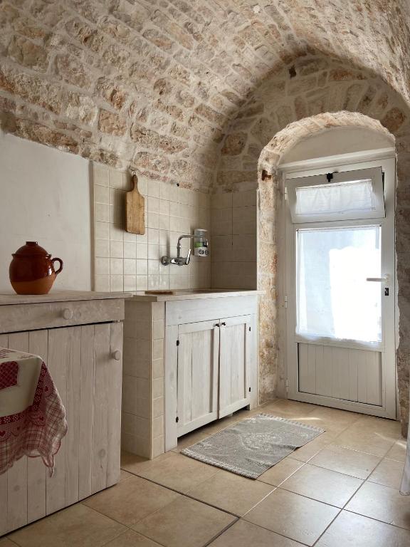 kuchnia ze zlewem i drzwi z oknem w obiekcie Trullo Zia Nina w Alberobello