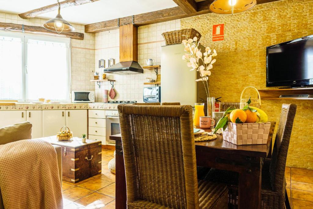a kitchen with a dining room table with chairs and a television at Rincon de Luna in Cuenca