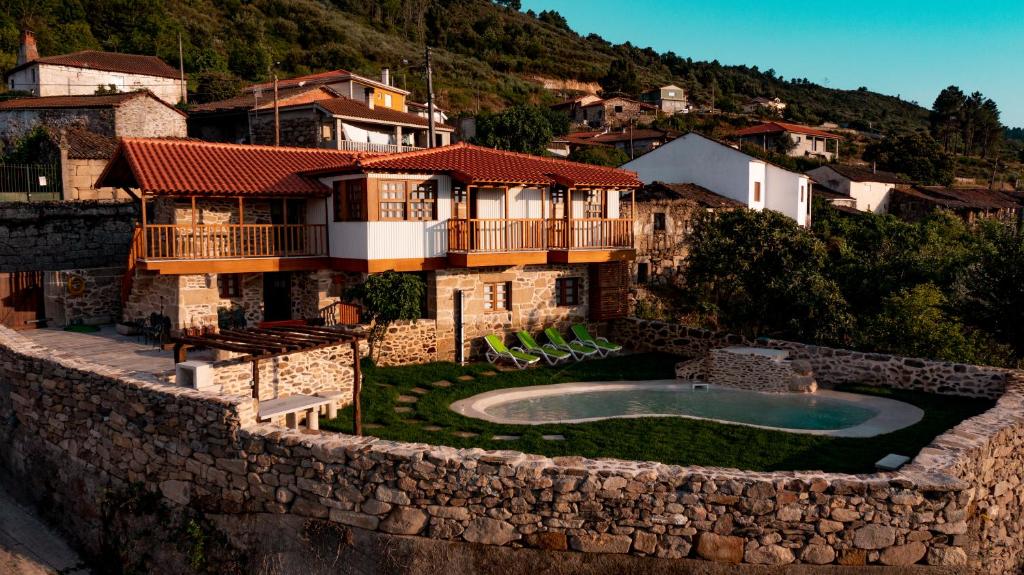 een huis met een zwembad aan een muur bij Casa da Mãe - Izei in Chaves