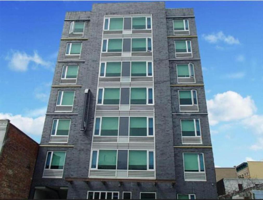 un edificio alto con muchas ventanas a un lado. en Umbrella Hotel Bronx en Bronx