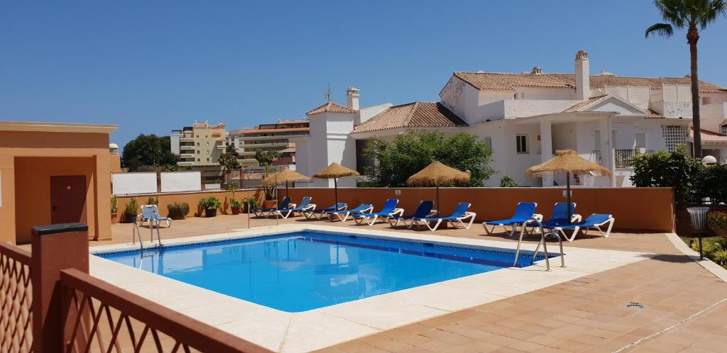 een zwembad met stoelen en parasols op een gebouw bij Riviera del Sol in Mijas Costa