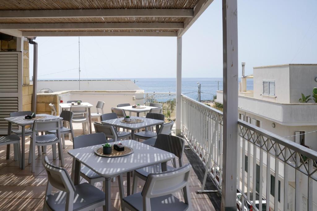 balkon ze stołami i krzesłami oraz oceanem w obiekcie B&B Sara w mieście Santa Maria al Bagno