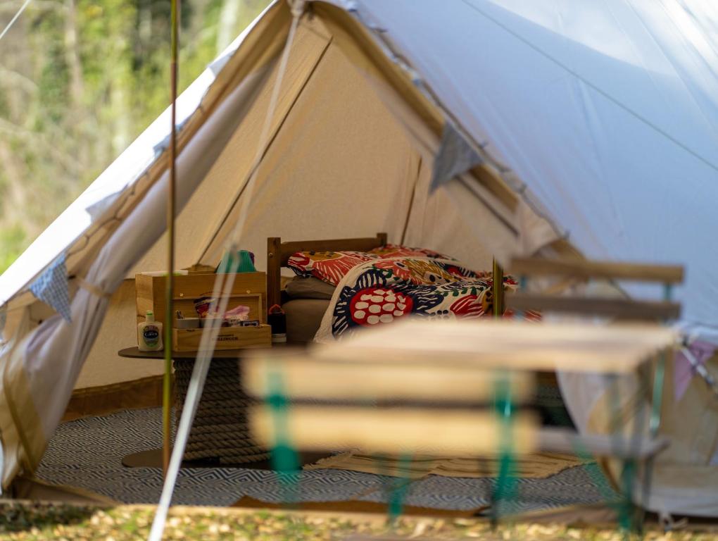 - une tente blanche avec un lit dans l'établissement Naturally Glamping, à Kingsteignton