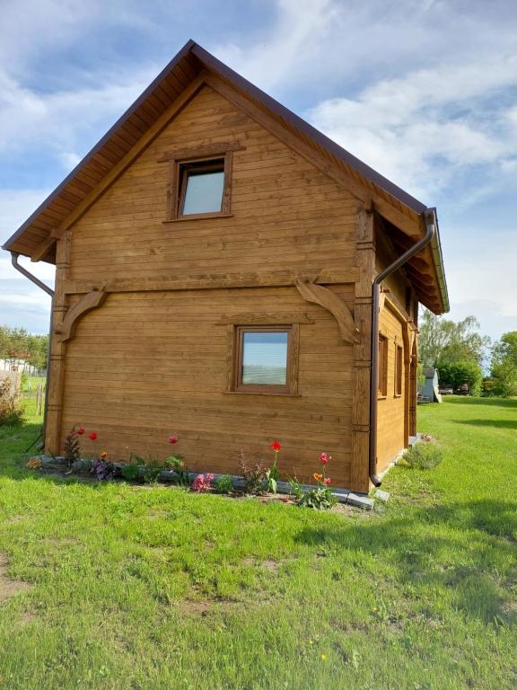 een klein houten gebouw met twee ramen in een veld bij Przytulisko in Smołdzino