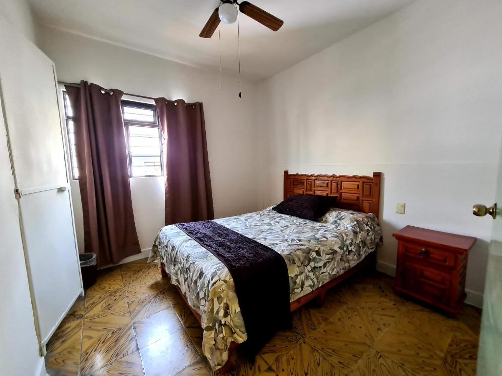 een slaapkamer met een bed en een plafondventilator bij Hotel Catalina in Orizaba