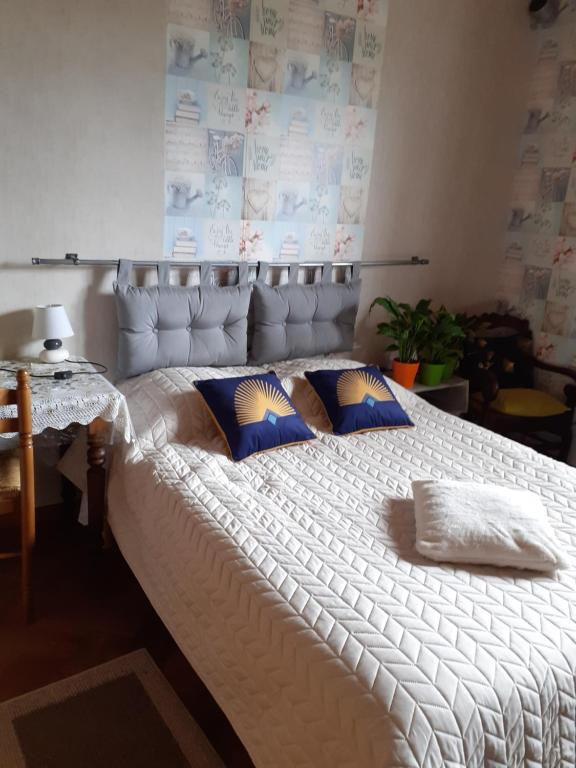 un grande letto bianco con cuscini blu sopra di Studio du gite a Wavrans-sur-lʼAa