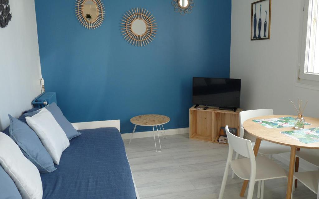 Sala de estar azul con sofá y mesa en "Le Suez" Appartement au bord de mer Catalans-Pharo, en Marsella