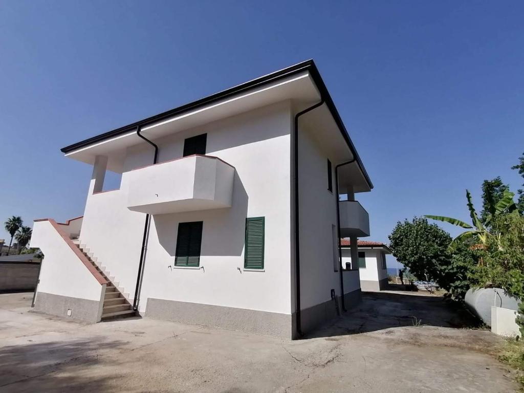 a white building with a large open door at Villa Bianca in Ioppolo