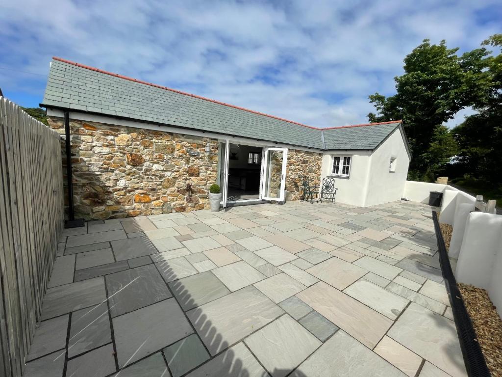 a patio in front of a stone house at Sunnyside Cow Shed one bedroom central Cornwall in Truro