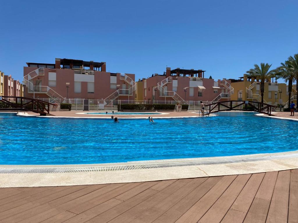 Una gran piscina azul con edificios al fondo. en Ruben House, en Vera