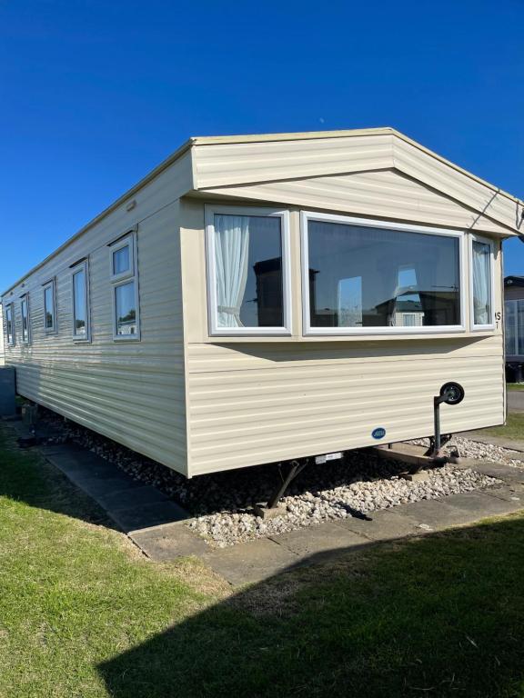 ein weißer Wohnwagen, der auf einem Grasfeld parkt in der Unterkunft Yellow 3 Caravan Ingoldmells 6 berth 3 bedrooms in Skegness