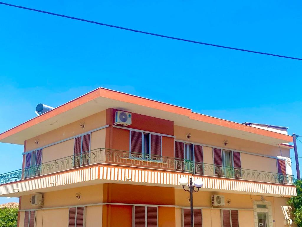 a orange and white building with a balcony at Dimitris apartment in Diakopto
