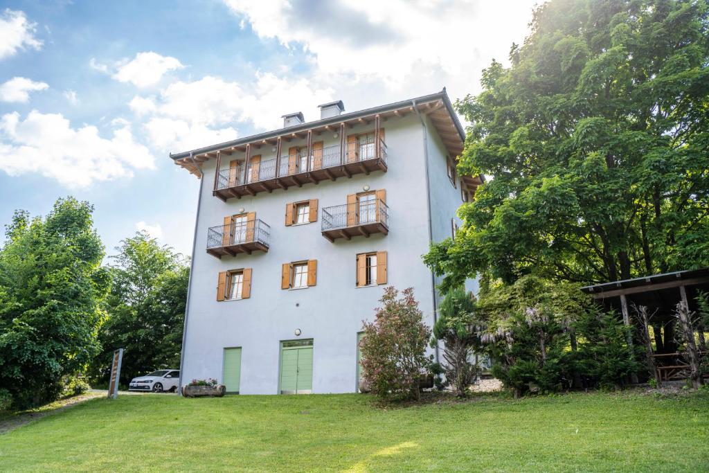 ein weißes Gebäude mit Fenstern und ein Grasfeld in der Unterkunft Cà dei Giani in Montagnaga