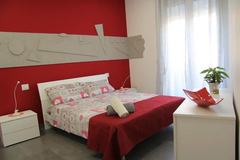 1 dormitorio rojo con 1 cama con pared roja en How Beach,modern apartment close to the beach,WiFi, en Cassibile