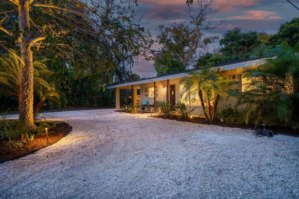 uma casa com uma entrada de cascalho em frente em Beautiful Glam Mid-Century 1 block from Sarasota bay with Firepit em Sarasota