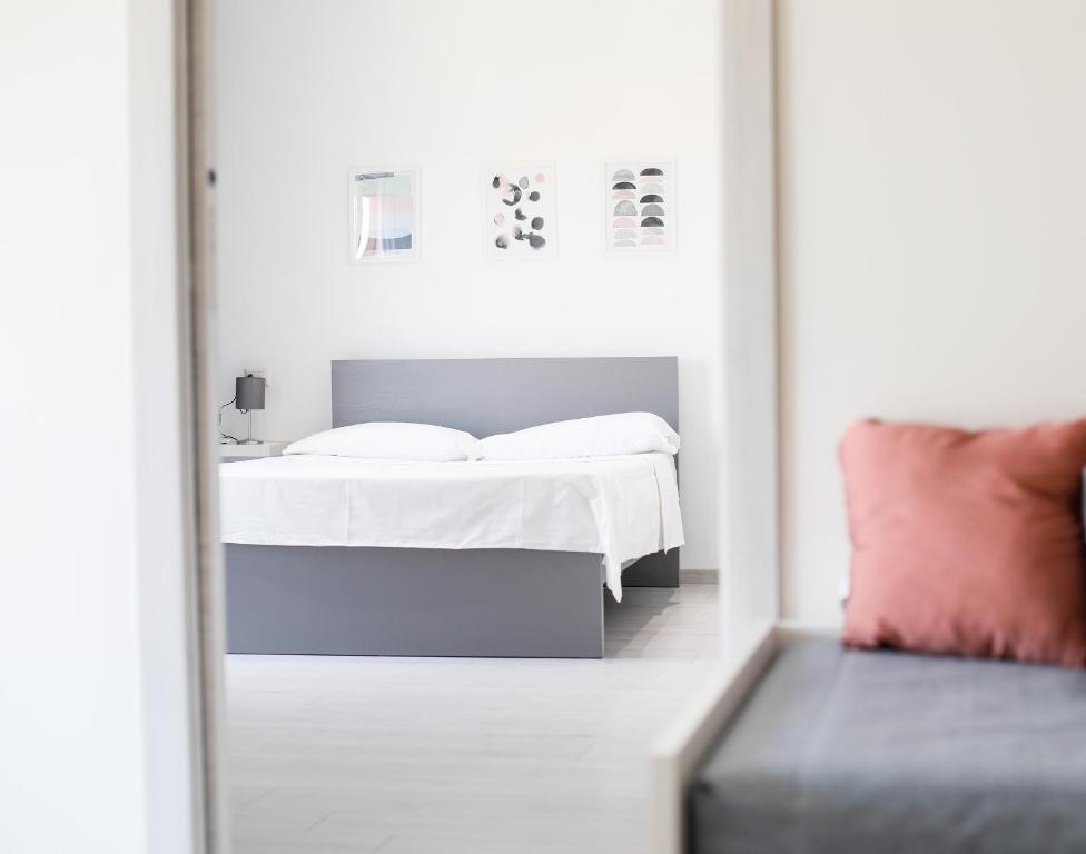 a bedroom with a white bed and a mirror at Sofíta - Rooms & Apartment in SantʼAgata di Militello