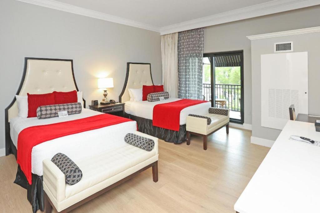 a hotel room with two beds and a balcony at Inn On Fifth in Naples