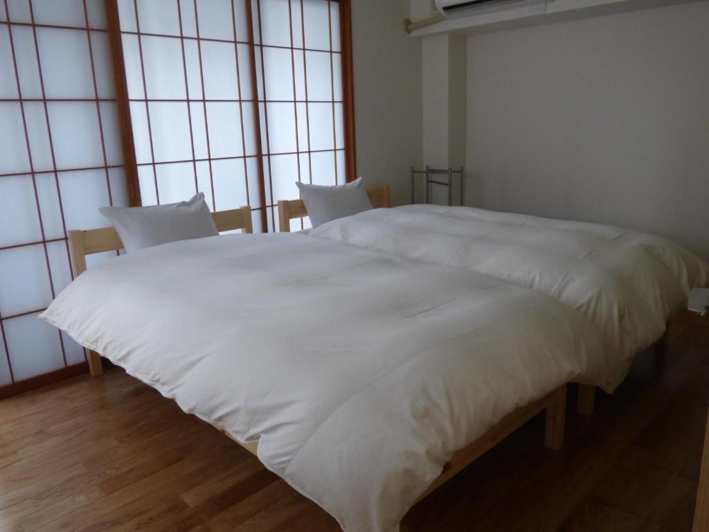 uma grande cama branca num quarto com janelas em Kyoto City - Hotel - Vacation STAY 88891v em Quioto