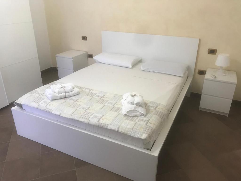 ein weißes Bett mit zwei weißen Handtüchern darauf in der Unterkunft Casalhouse Apartment in Brindisi