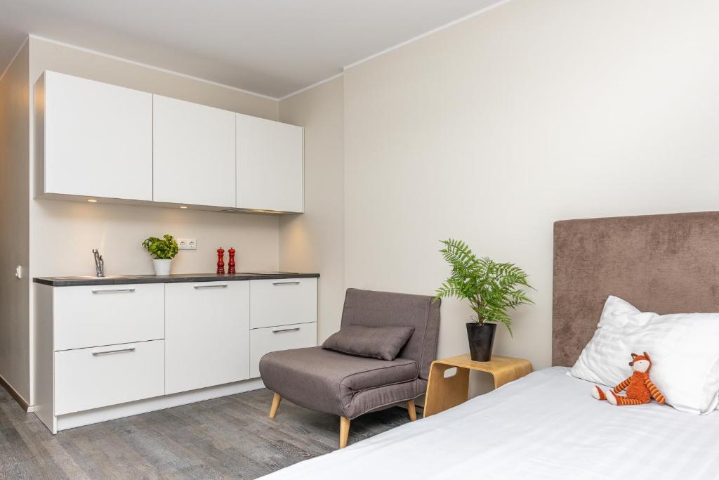 a bedroom with a bed and a chair at Aisa 39 Apartments in Pärnu