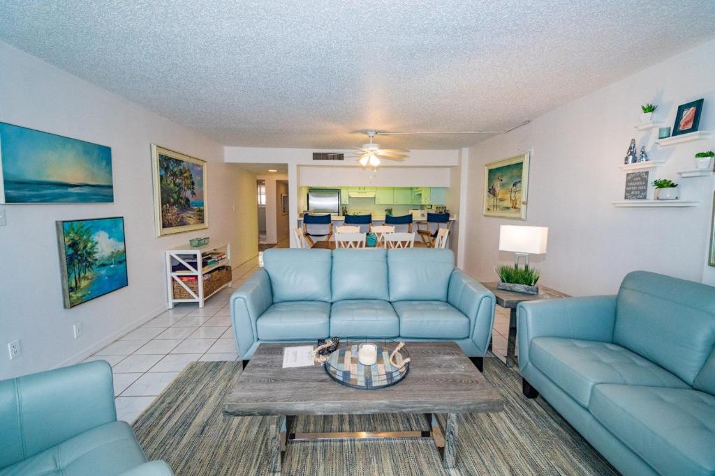 Una sala de estar con sofás azules y una mesa. en Sand Dollar 1-306, en St. Augustine
