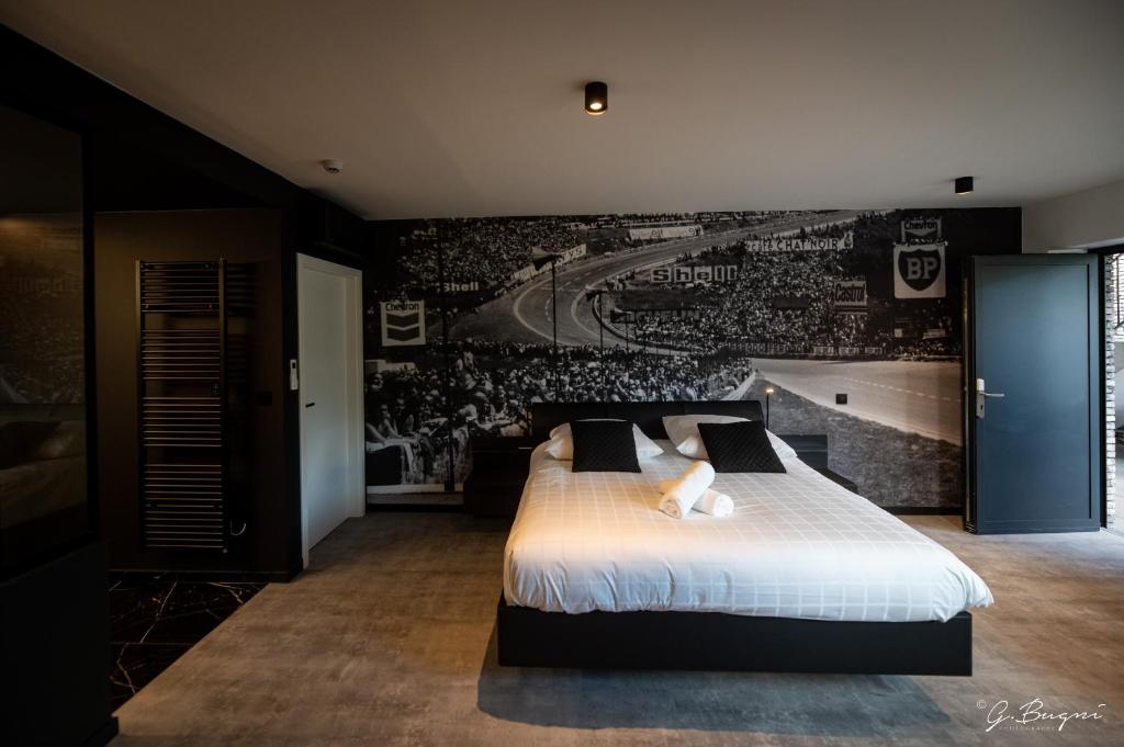 スパにあるBoutique Hôtel, La Cour de la Reine, Rooftop city centerのベッドルーム1室(大型ベッド1台付)、壁に野球ゲームが備わります。