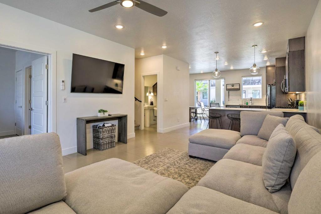 a living room with a couch and a tv and a kitchen at Sunny Resort Townhome and Balcony and Pool Access in St. George