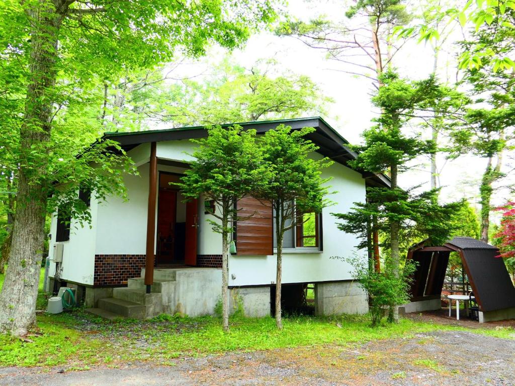 a small white house in the woods at Minamitsuru-gun - Cottage - Vacation STAY 96482v in Yamanakako