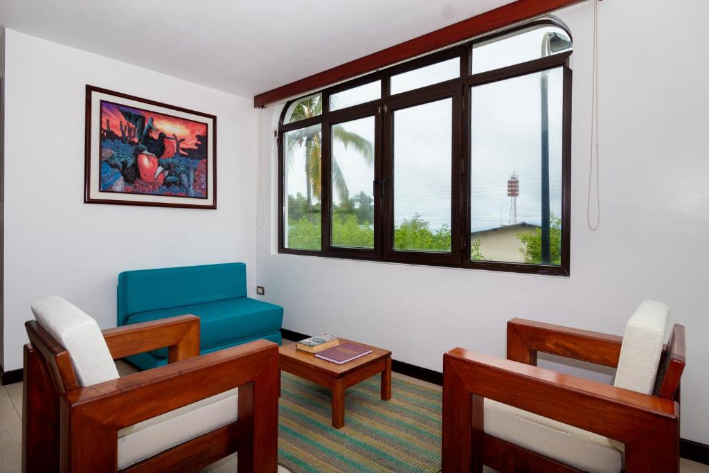 sala de estar con mesa, sillas y ventana en Galapagos Apartments - Bay View House, en Puerto Ayora