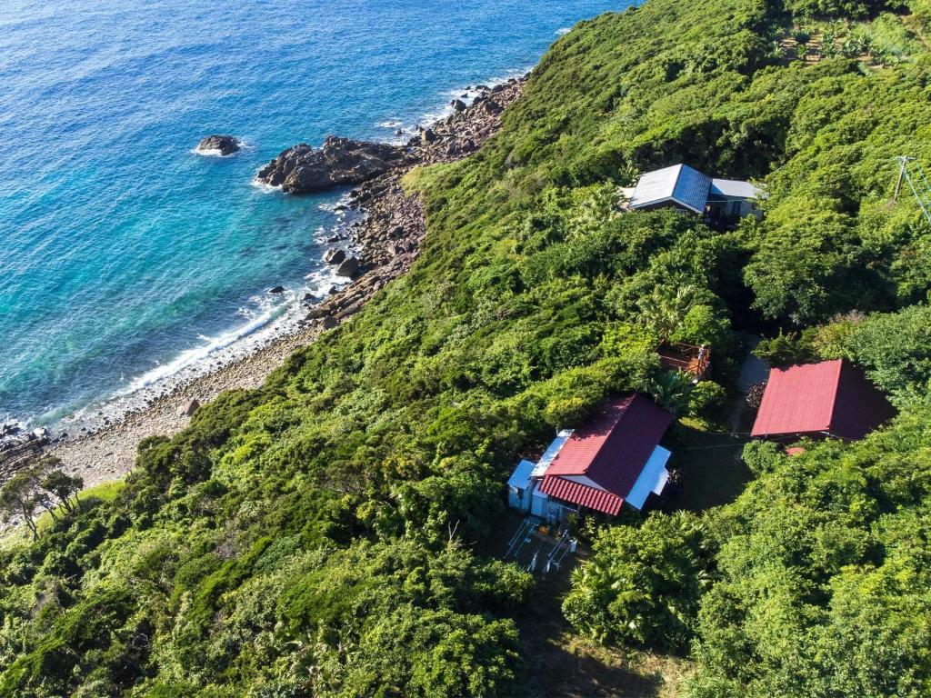 - une vue aérienne sur une maison située sur une colline à côté de l'océan dans l'établissement Hide A Way - Vacation STAY 90104v, à Nishinoomote