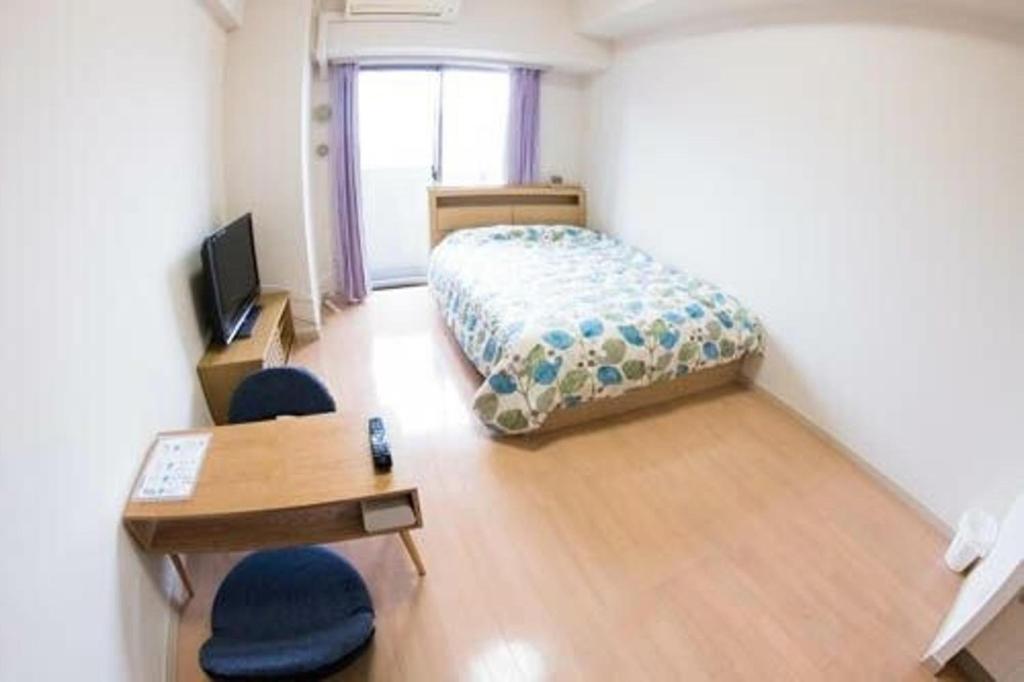 um quarto com uma cama, uma secretária e cadeiras em Carsail Sole - Vacation STAY 13225 em Saitama
