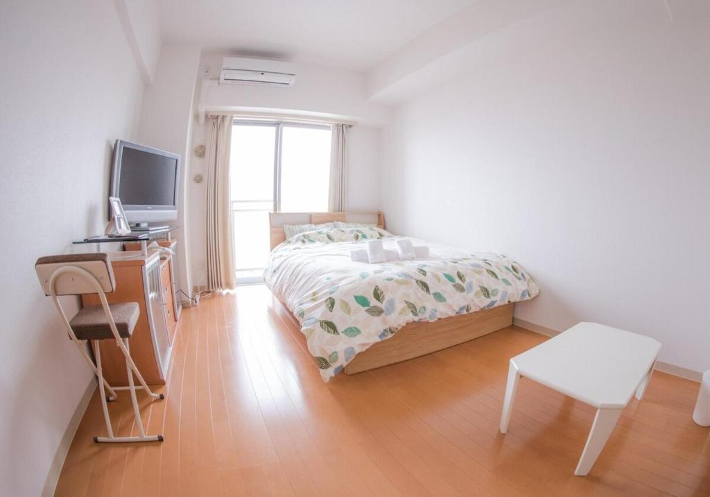 Schlafzimmer mit einem Bett, einem Schreibtisch und einem TV in der Unterkunft Carsail Sole - Vacation STAY 13224 in Saitama