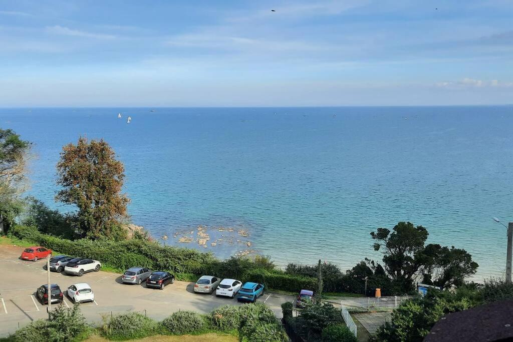 - un groupe de voitures garées dans un parking à côté de l'océan dans l'établissement Appartement pleine vue mer au bord de la plage, à Binic