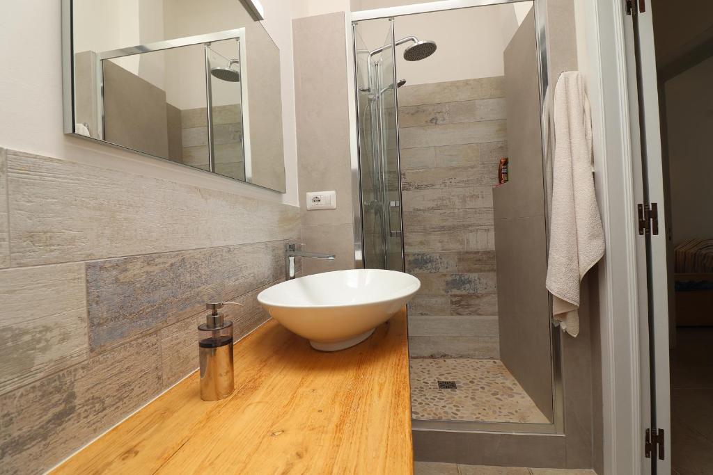 W łazience znajduje się biała umywalka i prysznic. w obiekcie Casa Paola Otranto w mieście Otranto