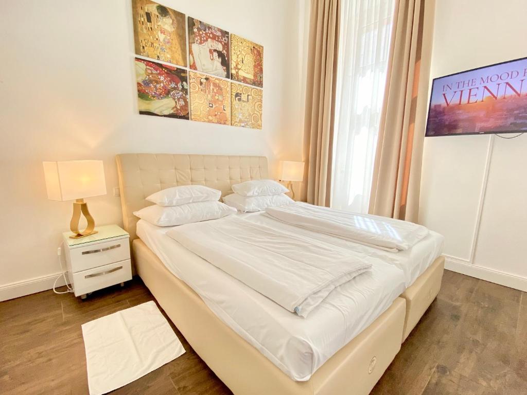 a bedroom with a bed with white sheets and a window at Steiner Residences Vienna Taborstrasse in Vienna