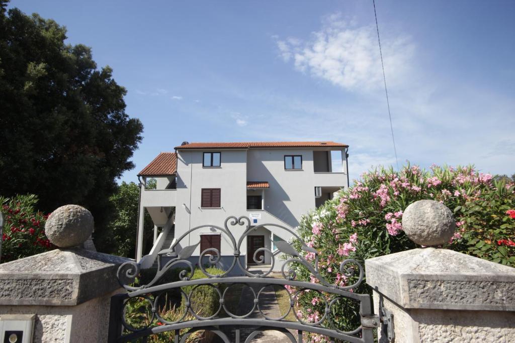 una casa blanca con una puerta y flores en Apartments Smitran en Banjole