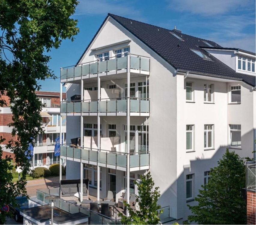ein weißes Apartmenthaus mit Balkon in der Unterkunft Nordic Wave Apartments in Timmendorfer Strand