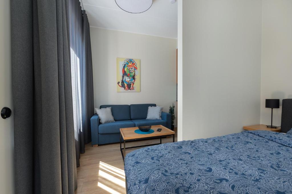 a bedroom with a blue bed and a couch at TartuKodu Vallikraavi 14-5 in Tartu