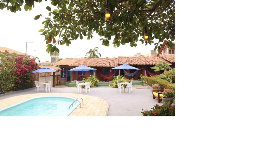 um resort com piscina, mesas e cadeiras em Pousada Vila do Mar em São Luís