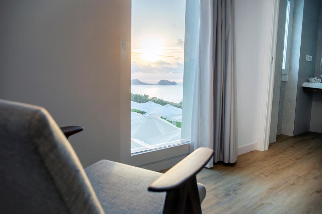 Zimmer mit einem Stuhl und einem großen Fenster in der Unterkunft Hotel Boutique Berazadi Berri in Zarautz