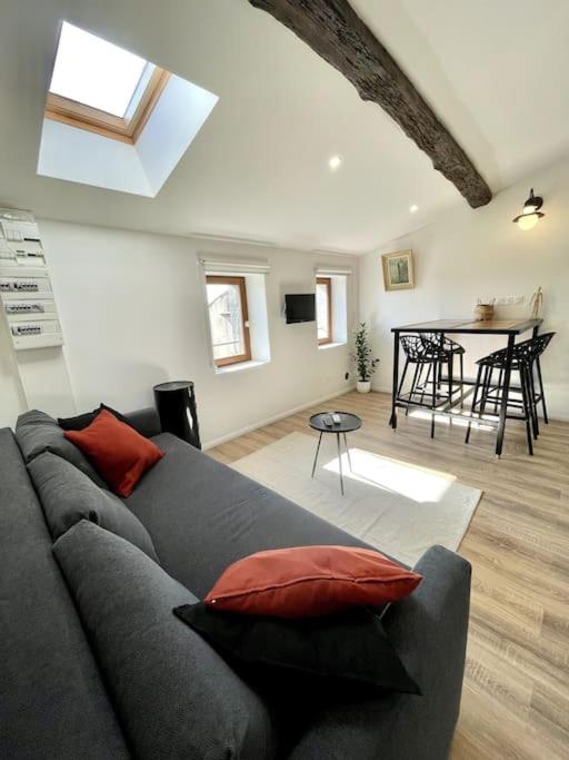 ein Wohnzimmer mit einem grauen Sofa und einem Tisch in der Unterkunft NEW, La Passante, Belle vue in Conques-sur-Orbiel