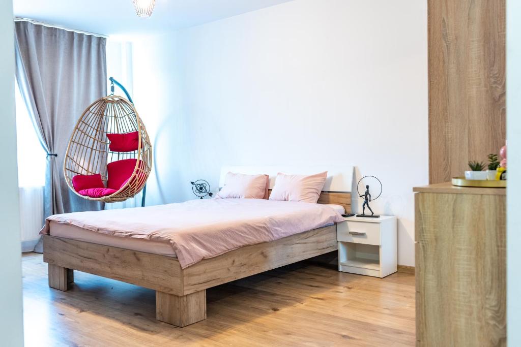 a bedroom with a bed and a hanging chair at Thome Hoia Studio 1Bedroom in Cluj-Napoca