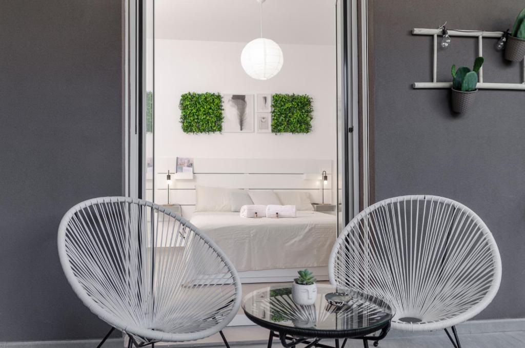 2 sedie e un tavolo di fronte a una camera da letto di [ApuliaLux] Design Apartment - Relax, SPA e Free Parking a Bari