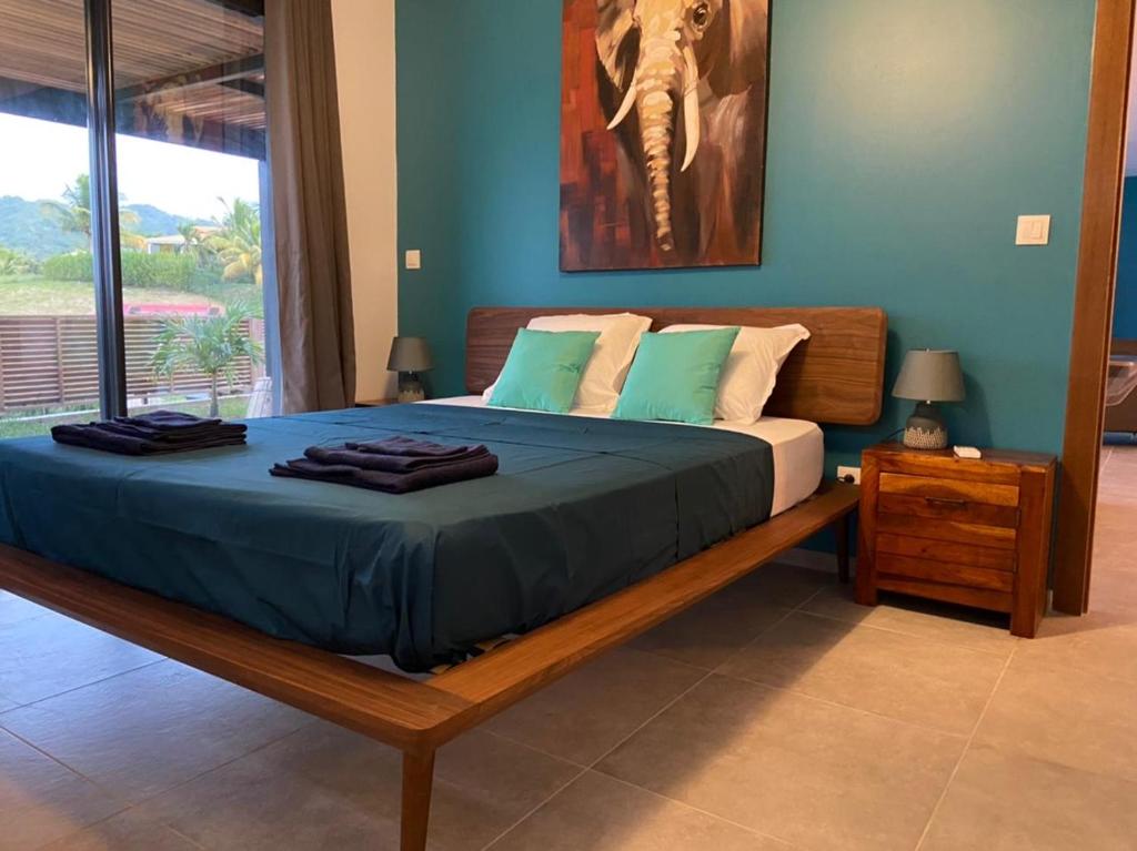 Tempat tidur dalam kamar di Villa Passion Cannelle de standing avec sa piscine vue mer