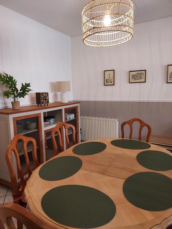 a dining room with a wooden table and chairs at Sous murs, petite maison de ville au charme authentique in Auxerre