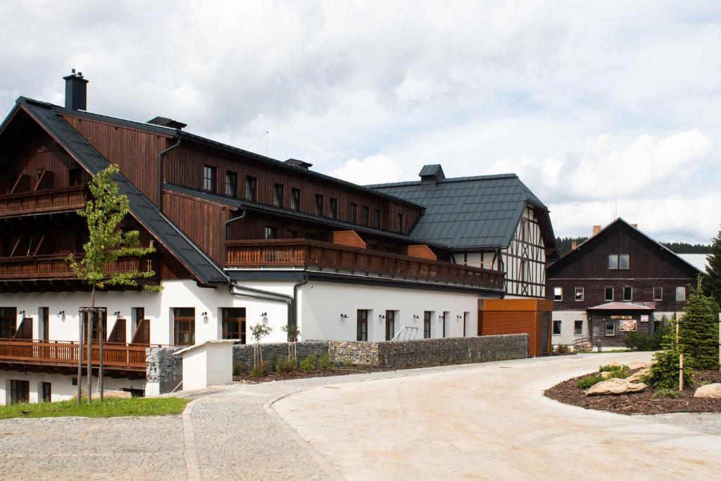 a large white building with a black roof at Wellness Apartmán Pila Kvilda in Kvilda