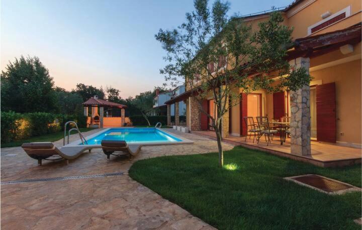 een zwembad in een tuin naast een huis bij I & M Guest House in Banjole