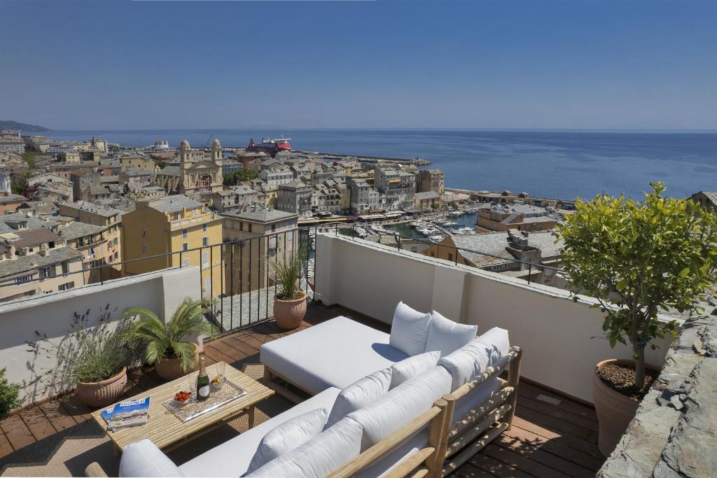 Elle comprend un balcon doté d'un mobilier blanc et offrant une vue sur la ville. dans l'établissement U Granaghju, à Bastia